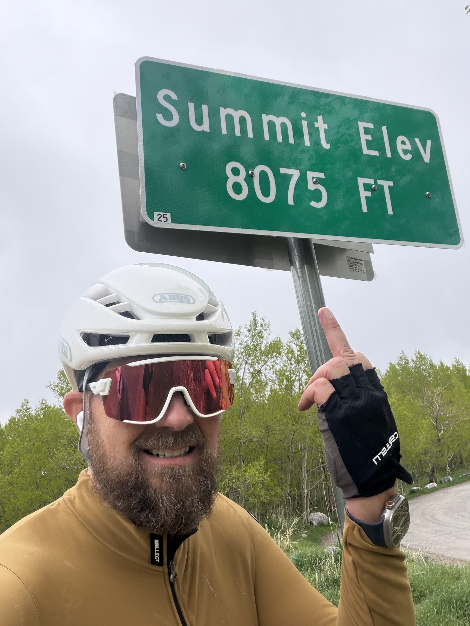Ryan pointing at Summit Elev 8075 FT sign